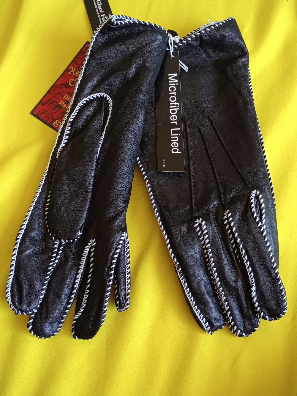 Grandoe black leather gloves featuring contrast white whipstitching and a microf